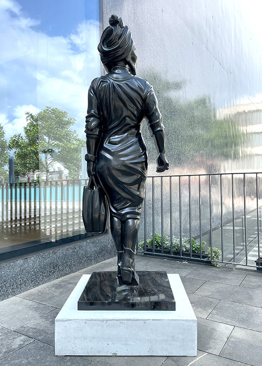 Bronzeskulptur einer Frau mit Tasche von Georg Loewit